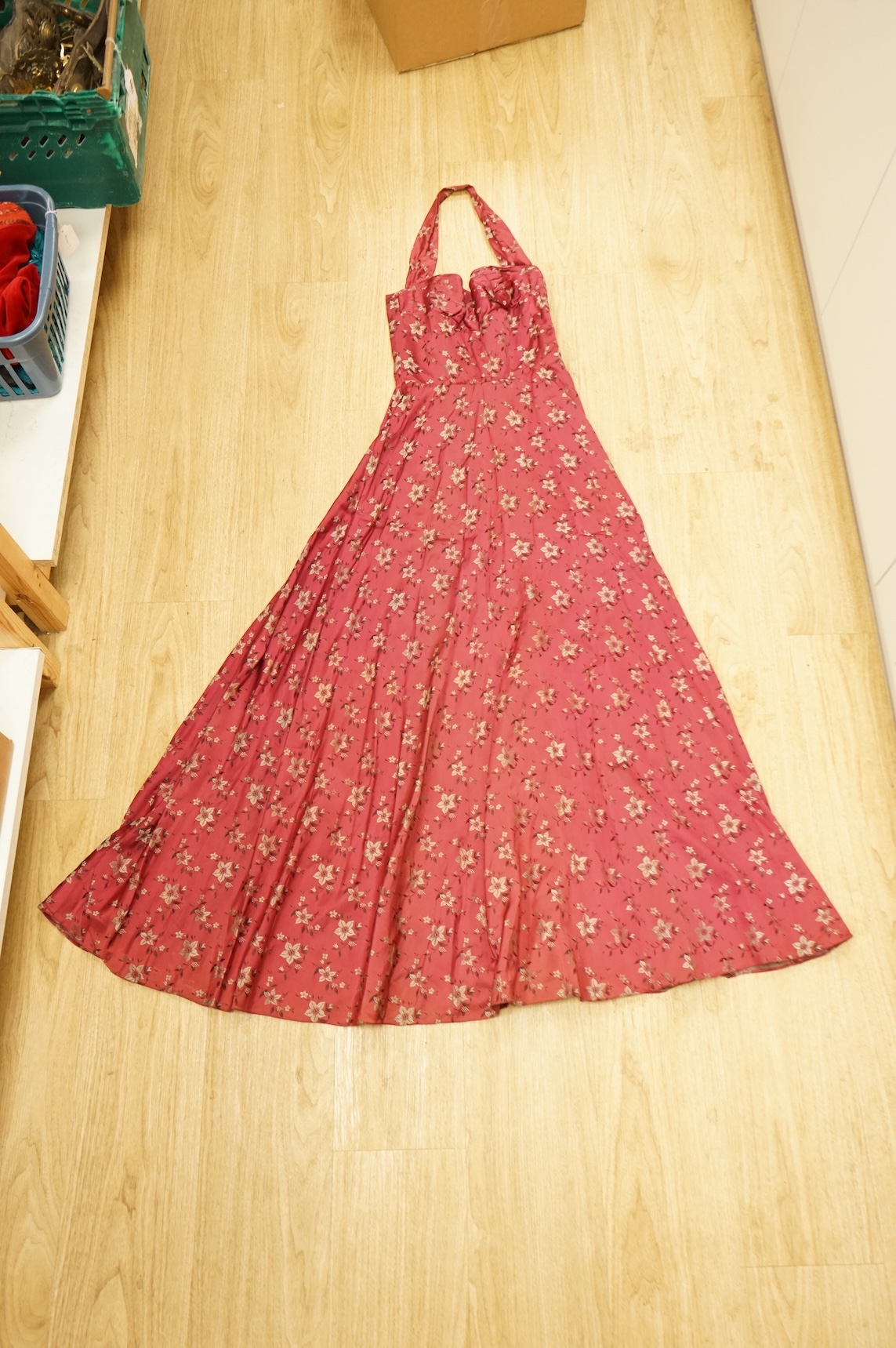 A late 1940’s black lace evening dress, a similar evening dress with black velvet ribbon detail, a maroon brocade halter neck evening dress and a dark mustard early 1950’s evening silk duster coat.